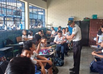Agente de policia habla con los niños de una escuela en un programa de prevención del delito